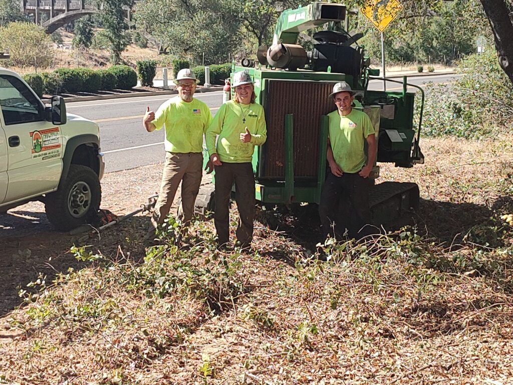 Aaron, Richard, and Travis with a wood chipper on commercial property.